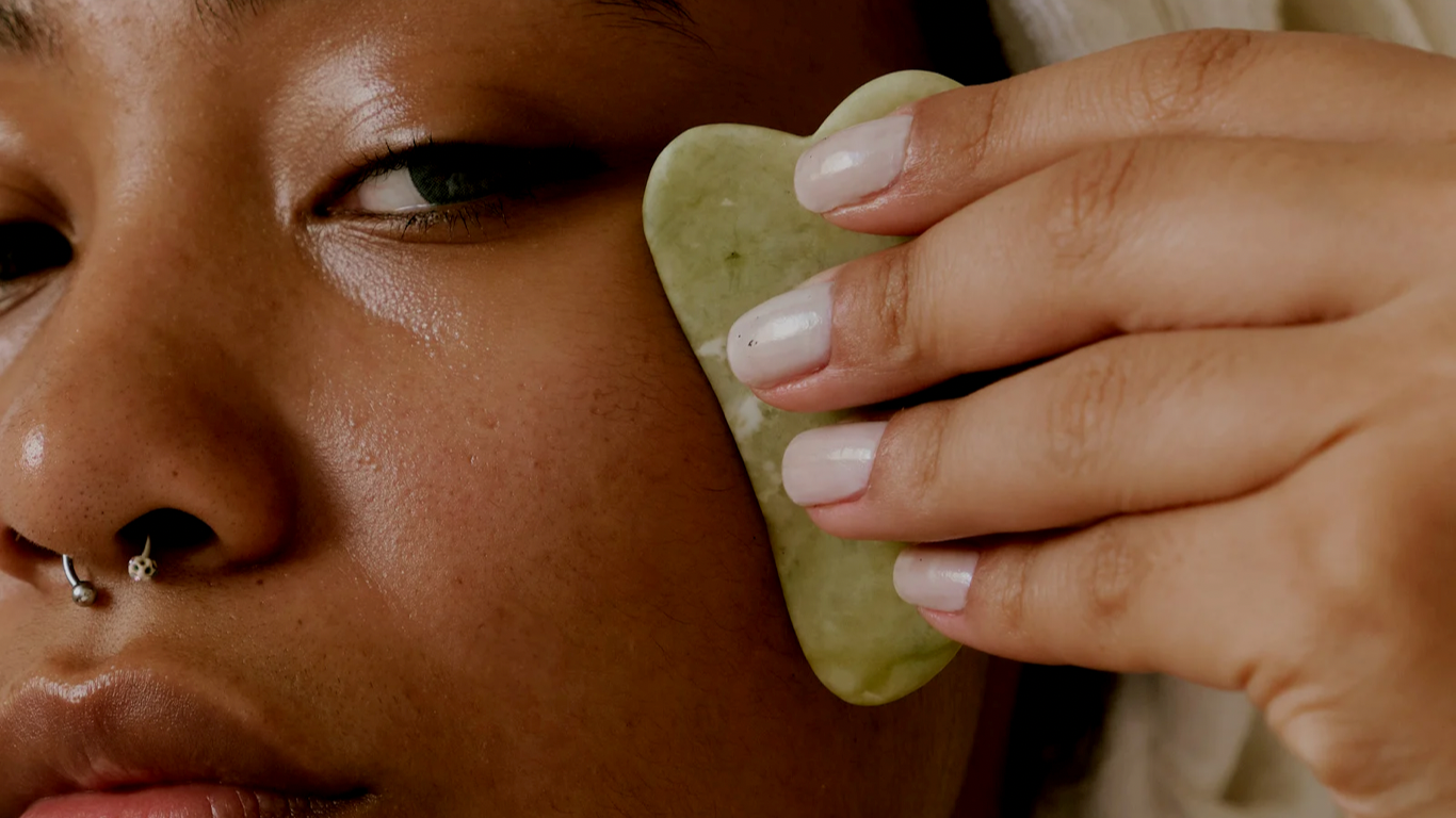 A woman holding a skincare accessories to her face 